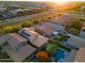 Aerial view of rooftops and swimming pools in a suburban neighborhood at sunset at 4084 E Rawhide St, Gilbert, AZ 85296