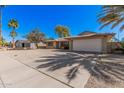 Single-story home with a two-car garage, mature trees, desert landscaping, and a long driveway at 4533 S Terrace Rd, Tempe, AZ 85282