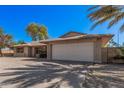 Single-story home featuring a two-car garage, desert landscaping, and mature trees at 4533 S Terrace Rd, Tempe, AZ 85282
