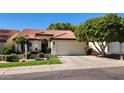 Beautiful single-story home featuring a tiled roof, a well-maintained yard, and an attached two car garage at 5055 E Paseo Way, Phoenix, AZ 85044