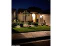Attractive single-story home at night, showcasing professional landscape lighting and lush, manicured front lawn at 5055 E Paseo Way, Phoenix, AZ 85044