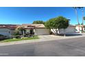 Inviting single-story home boasting a red tile roof, mature tree in the front yard, and an attached two-car garage at 5055 E Paseo Way, Phoenix, AZ 85044