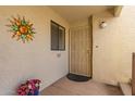 Front entrance with decorative security door, potted flowers, and a sun-shaped wall decoration at 5518 E Lindstrom Ln # 2011, Mesa, AZ 85215