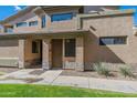 View of the entrance to the tan townhome with desert landscaping on a sunny day at 705 W Queen Creek Rd # 2158, Chandler, AZ 85248