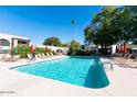 Sparkling community pool surrounded by lounge chairs and lush landscaping at 7663 E Pleasant Run, Scottsdale, AZ 85258