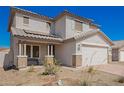 Attractive home with a welcoming front porch, stone accents, and a two-car garage for ample parking at 8430 W Atlantis Way, Tolleson, AZ 85353