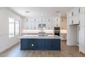 Modern kitchen featuring white cabinetry, stainless steel appliances, and a large island with a marble countertop at 11188 N Blakely St, Surprise, AZ 85388