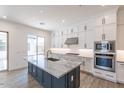 Modern kitchen featuring white cabinetry, stainless steel appliances, and a large island with a marble countertop at 11188 N Blakely St, Surprise, AZ 85388