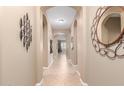 Long hallway featuring arched entryways and neutral decor, tile flooring, wall art at 11915 S 184Th Ave, Goodyear, AZ 85338