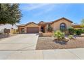 Well-maintained single-story home with tile roof, desert landscaping, and a two-car garage at 15881 W Berkeley Rd, Goodyear, AZ 85395