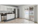 Kitchen featuring white cabinets, stainless steel appliances, and a pass-through to the back patio at 1747 W Belfast St, Mesa, AZ 85201