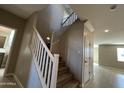 Carpeted staircase with white banister leading to the second floor of the home at 17541 W Lupine Ave, Goodyear, AZ 85338