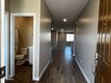 Welcoming entryway features wood-look tile flooring leading to an open floor plan and a view of the downstairs bathroom at 17558 W Lupine Ave, Goodyear, AZ 85338