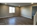 Spacious living room with wood-look tile flooring, recessed lighting, and a window providing natural light at 17558 W Lupine Ave, Goodyear, AZ 85338