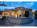 Charming exterior featuring a quaint patio with seating and desert landscaping at twilight at 17642 N Ironhorse Dr, Surprise, AZ 85374