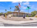 Single-story home with a two-car garage, low maintenance yard, and street signs in view at 18402 N 94Th Dr, Sun City, AZ 85373