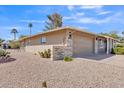 Rear view of home featuring desert landscaping, a two-car garage, and neutral paint at 18402 N 94Th Dr, Sun City, AZ 85373