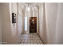 Cozy home entryway featuring tile flooring, light-colored walls, and a wooden front door at 18660 N 71St Ln, Glendale, AZ 85308