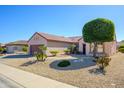 Charming single-story home showcases neat desert landscaping and a neutral color scheme at 20047 N Shadow Mountain Dr, Surprise, AZ 85374