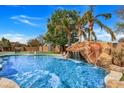 Resort-style pool area with a waterfall feature, surrounded by lush landscaping at 3120 E Waterman Ct, Gilbert, AZ 85297