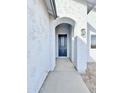 Inviting entryway with arched entrance, modern lighting and a sleek, dark front door at 4240 N Arizona Rd, Eloy, AZ 85131