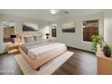 Cozy bedroom features neutral walls, modern furnishings, ceiling fan, and natural light from the windows at 42618 W Oakland Dr, Maricopa, AZ 85138