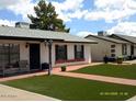 Well-kept single-story home featuring green artificial grass and a red brick walkway at 4606 E Cheyenne Dr, Phoenix, AZ 85044
