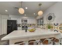 Bright, spacious kitchen with modern appliances, a breakfast bar, and unique backsplash design, creating a stylish cooking space at 4826 W Michigan Ave, Glendale, AZ 85308