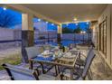 Covered patio with dining set, ideal for outdoor meals overlooking the sparkling pool and lush backyard at 4826 W Michigan Ave, Glendale, AZ 85308