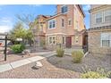 Inviting townhome showcases stone detailing, complemented by a landscaped yard and a wrought-iron fenced front porch at 7815 W Monte Vista Rd, Phoenix, AZ 85035