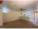 Spacious living room featuring neutral carpet, connecting to a kitchen with white cabinetry and appliances at 8255 E Kiva Ave # 424, Mesa, AZ 85209