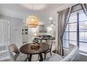 Bright dining room with a wood table, stylish light fixture, and open access to the living room at 11011 N 92Nd St # 1157, Scottsdale, AZ 85260