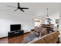 Inviting living room with vaulted ceilings, wood floors, and comfortable leather seating with a fan at 12007 S Crow Ct, Phoenix, AZ 85044