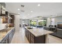 Spacious open-concept kitchen with stainless steel appliances, granite island, and seamless flow to the living area at 13418 W Mayberry Trl, Peoria, AZ 85383