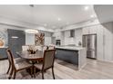 Modern kitchen with sleek gray cabinets, stainless steel appliances, and a large island with an adjacent dining area at 16580 N 92Nd St # 2003, Scottsdale, AZ 85260