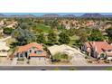 Community aerial view showcasing houses with red roofs, lush greenery, and a golf course in the background at 19277 N 78Th Ln, Glendale, AZ 85308