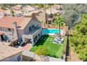 Aerial view of backyard with pool, patio, green lawn, and upper balcony, perfect for outdoor enjoyment at 19277 N 78Th Ln, Glendale, AZ 85308