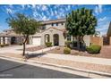 Inviting two-story home with mature trees, a well-kept lawn, and a charming front entrance at 21030 E Misty Ln, Queen Creek, AZ 85142