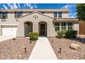 Charming home with beautiful landscaping, a two-car garage, and a welcoming front porch at 21030 E Misty Ln, Queen Creek, AZ 85142