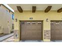Two-car garage with carriage style doors, stone accents, and decorative beams at 2725 E Mine Creek Rd # 2186, Phoenix, AZ 85024