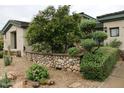 Landscaped front yard with custom stonework, mature trees, and gravel ground cover at 3957 N 148Th Dr, Goodyear, AZ 85395