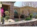 Cozy outdoor patio with stone accents, bougainvillea, and comfortable seating at 3957 N 148Th Dr, Goodyear, AZ 85395