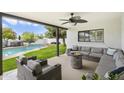 Relaxing covered patio featuring comfortable seating, a fire pit, and a view of the backyard pool area at 5629 E Thunderbird Rd, Scottsdale, AZ 85254
