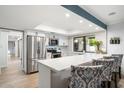 Modern kitchen with white cabinetry, stainless steel appliances, and a breakfast bar with seating at 5629 E Thunderbird Rd, Scottsdale, AZ 85254