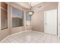 Bright breakfast nook with tile flooring, large window with blinds, and decorative chandelier at 6200 S Championship Dr, Chandler, AZ 85249