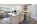 Modern kitchen with a large island, stainless steel appliances, and seamless flow to the living room at 7414 W Whitehorn Trl, Peoria, AZ 85383