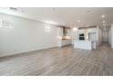 Open-concept living space with kitchen in the background, white walls, and wood-style tile flooring at 7414 W Whitehorn Trl, Peoria, AZ 85383