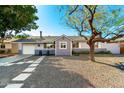 Charming single-story home featuring gravel landscaping, concrete pavers, and a fresh grey and white paint scheme at 8345 E Oak St, Scottsdale, AZ 85257