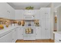 Bright kitchen featuring white cabinetry, light countertops, modern appliances, and stylish backsplash at 9231 E Carmel Ave, Mesa, AZ 85208