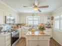 Bright kitchen featuring custom cabinets, stainless steel appliances, and wood flooring at 10417 W Deanne Dr, Sun City, AZ 85351
